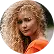 Marc Lefèvre Premium Care Premium Care Woman with curly blonde hair in an orange top looking toward the camera and smiling softly